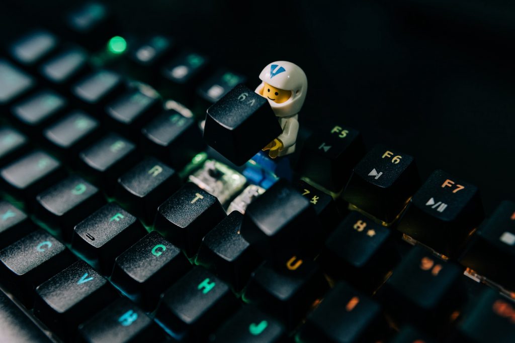 A lego-man holding a key taken out of a keyboard